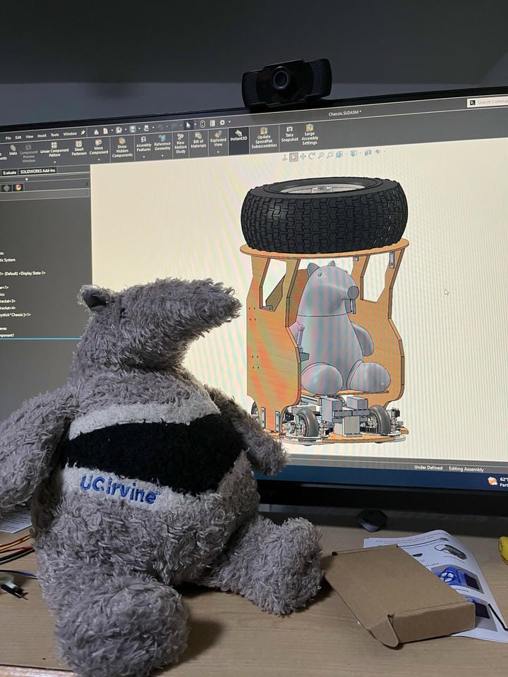 CAD model of the rover next to the plush of the driver